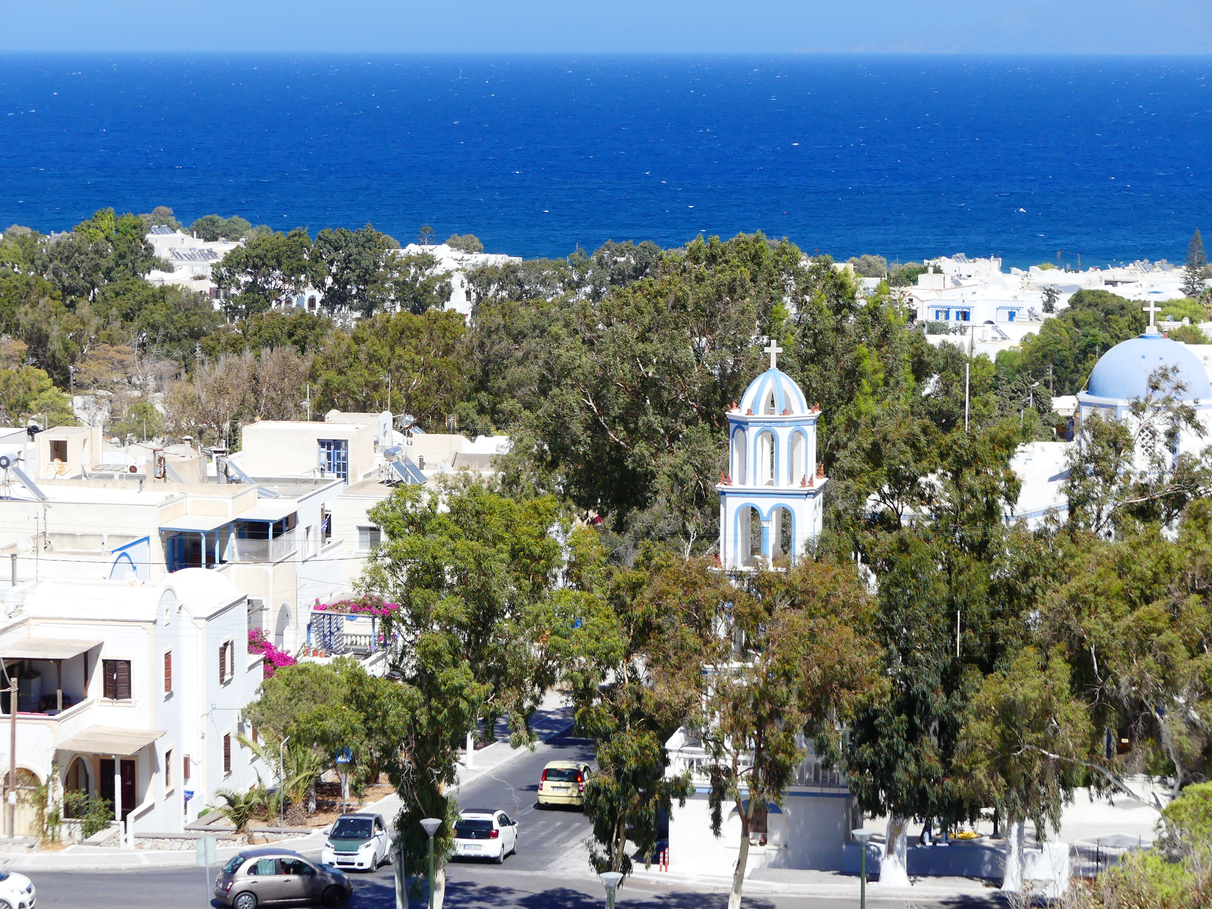 Promenade piétonne de Kamari — restaurants et terrasses le long de la plage de sable noir